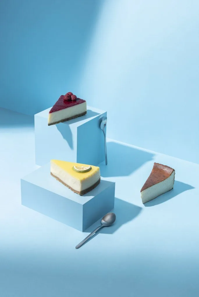 Açık mavi bloklar üzerinde cheesecake dilimleri, pastel zemin tatlı fotoğrafı