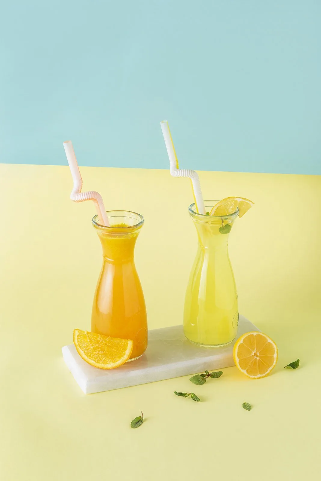 Sarı ve mavi zeminde portakal ve limon suyu şişeleri, içecek ürün fotoğrafı