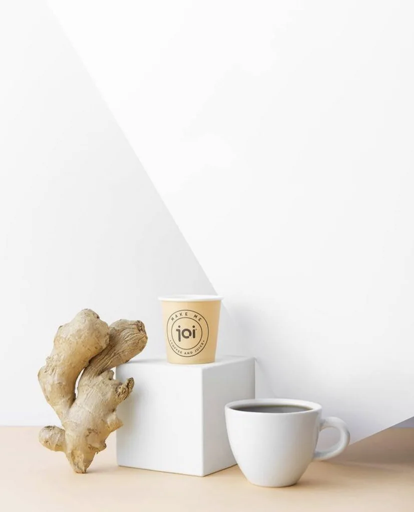 Beyaz zeminde zencefil kökü ve fincanda çay, minimal içecek fotoğrafı